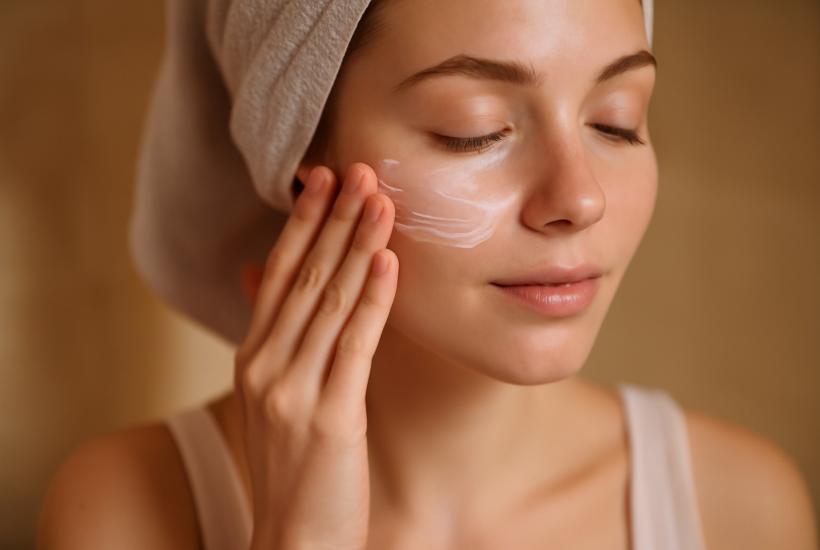 Женщина наносит увлажняющий бальзам на лицо