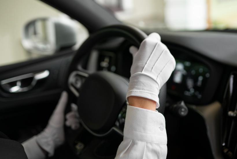 Руки водителя в перчатках на руле зимой (вид из салона)