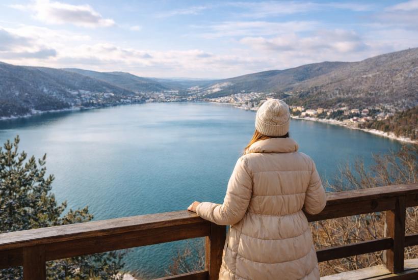 Девушка смотрит на озеро и горы