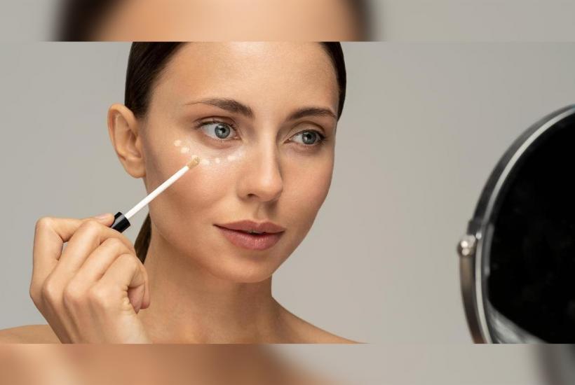 Девушка наносит консилер