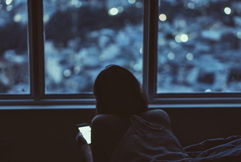 Девушка смотрит в экран смартфона Девушка смотрит в экран смартфона