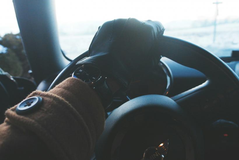 Руки водителя в перчатках на руле зимой (вид из салона)