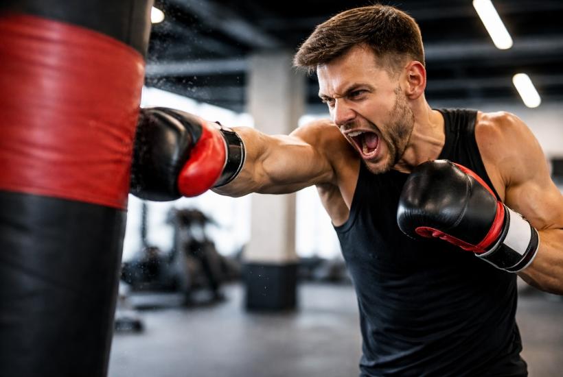 Мужчина бьет боксёрскую грушу