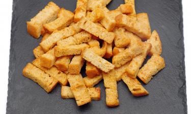 Для сухариков кубики хлеба нужно подсушить, пропитать чесночным маслом