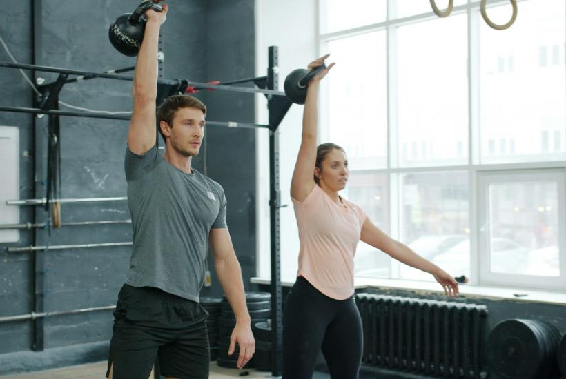 Человек занимается с гирей