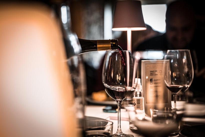 Эстетичный бокал красного вина на фоне ужина