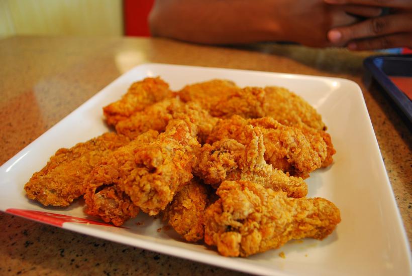 Тарелка горячих крылышек подается в ресторане KFC Тарелка горячих крылышек подается в ресторане KFC