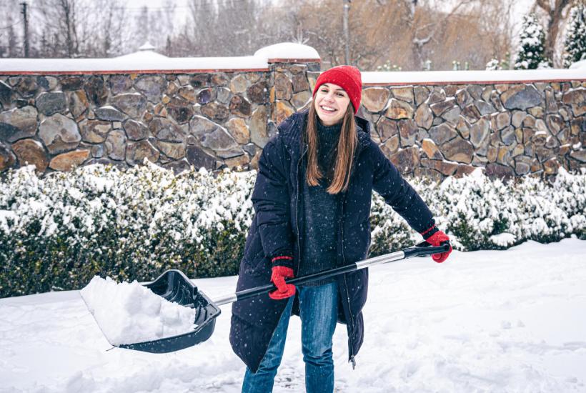 Девушка чистит снег