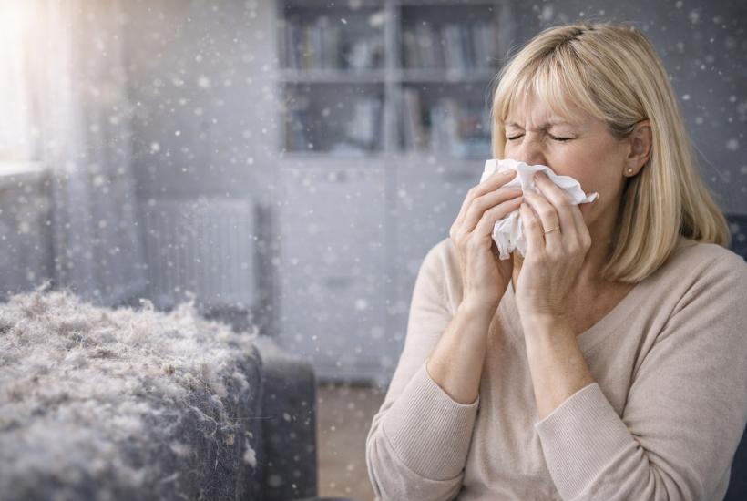 Девушка чихает от пыли дома