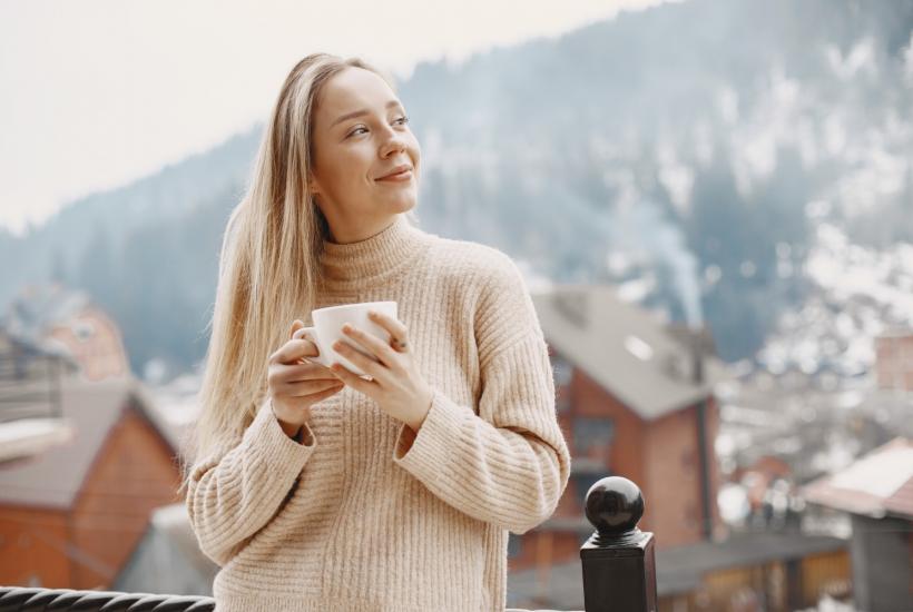 Девушка пьет кофе в горах