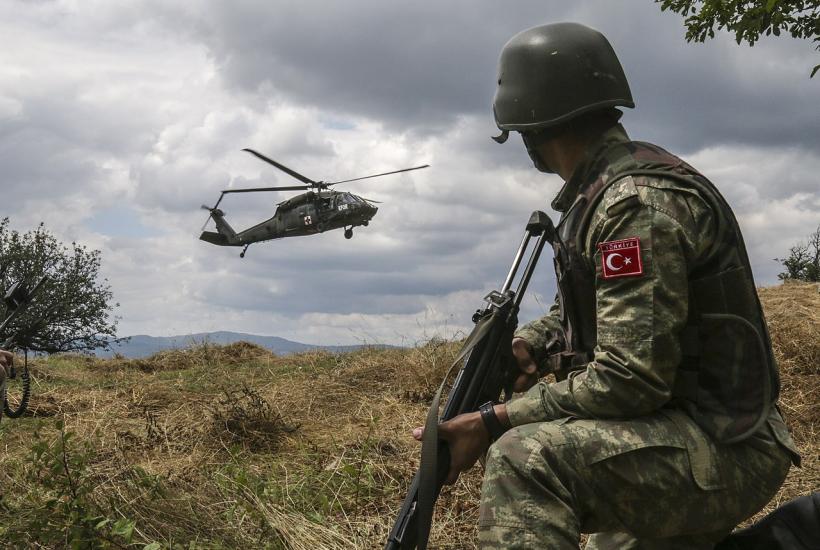 Турецкий солдат из Многонациональной боевой группы Восток наблюдает, как вертолёт UH-60 Блэк Хок готовится к посадке после получения девятистрочного вызова об условной потере