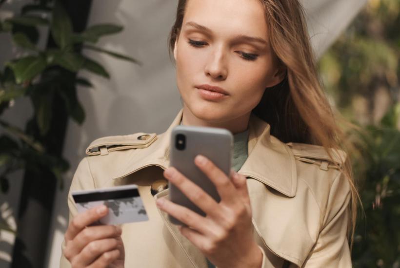 Девушка расплачивается картой в телефоне
