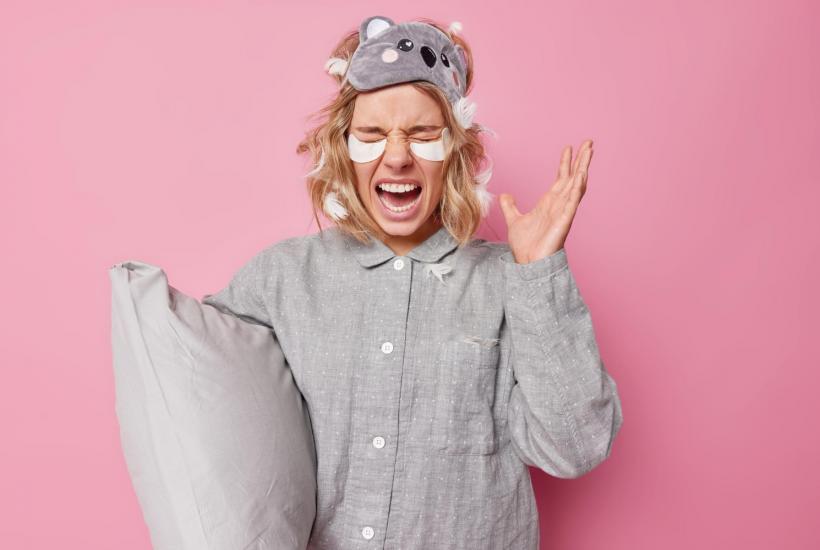 Девушка с подушкой зевает